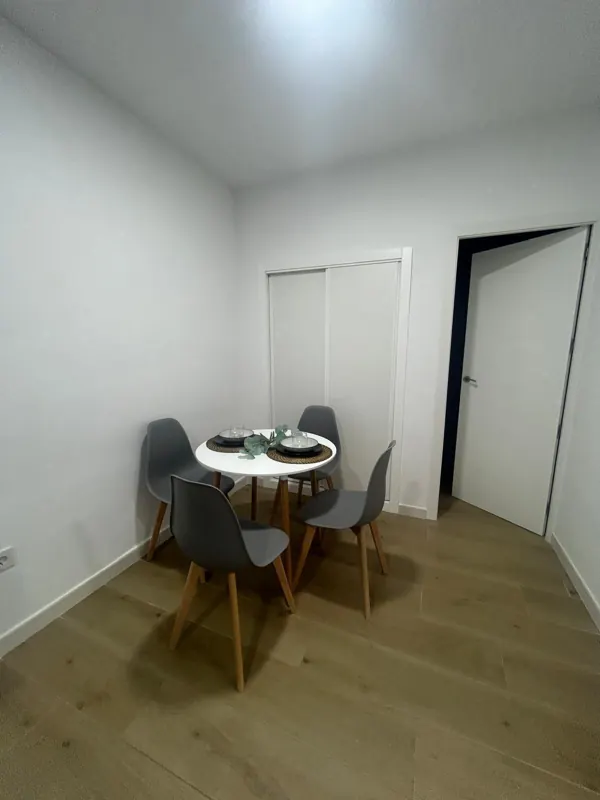 Comedor con armario empotrado de puertas correderas blancas y mesa redonda