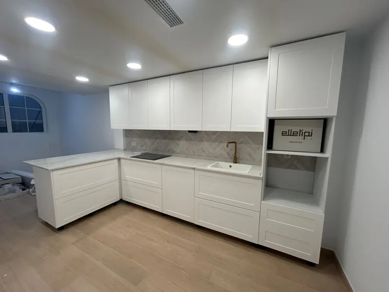 Cocina reformada en Córdoba con muebles blancos hasta el techo y suelo laminado
