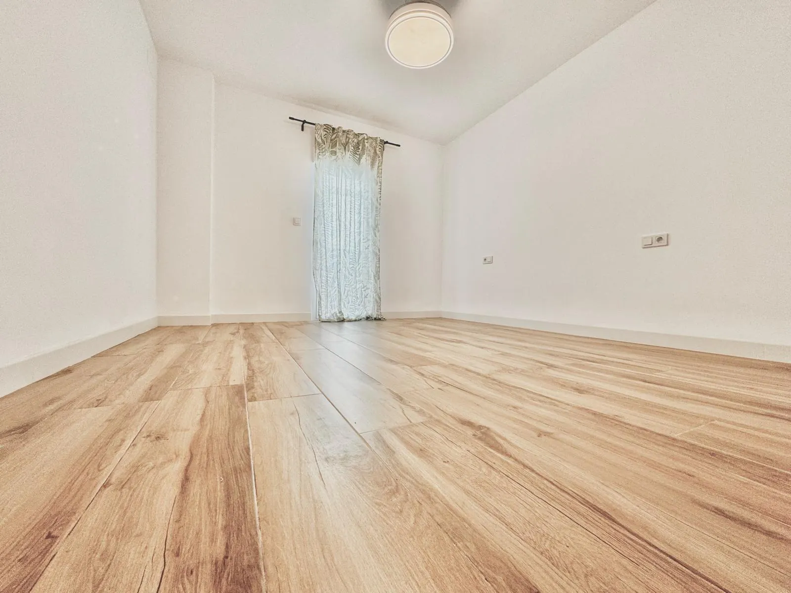 Salón con suelo laminado roble recién instalado sobre el suelo antiguo, en un piso de Córdoba